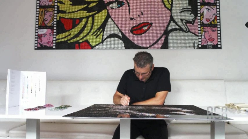 Yago Sánchez placing crystals by hand on a mosaic portrait