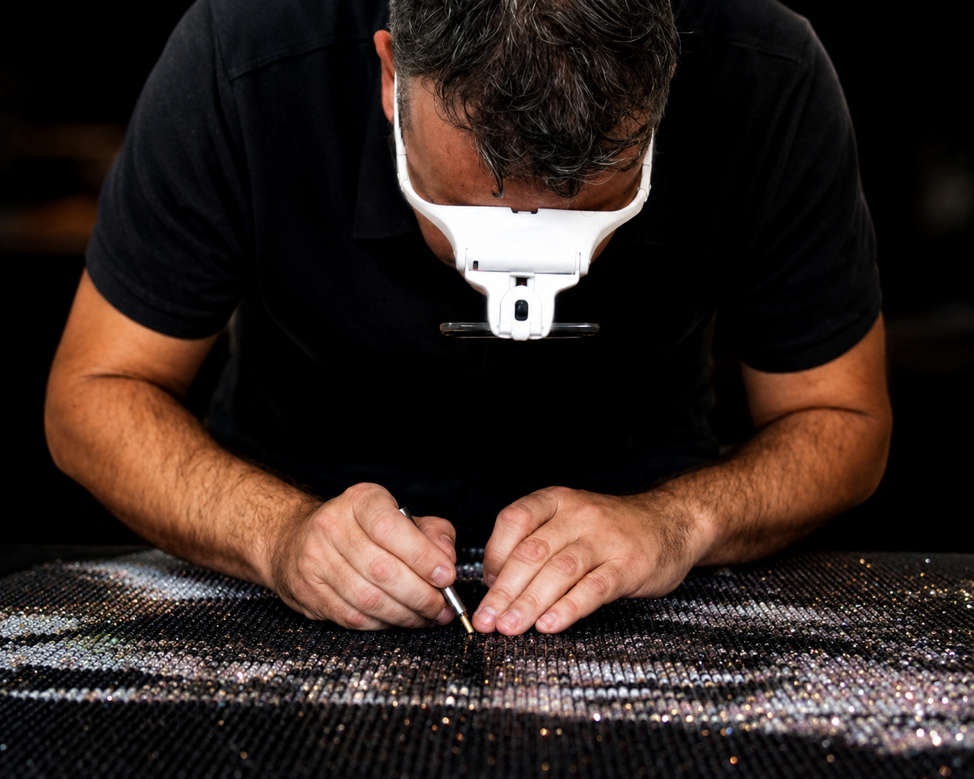 The artist studying crystals through a magnifying glass